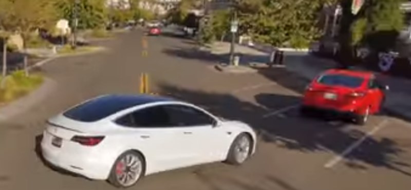 Szép drónos felvétel egy önvezető Tesláról, amint majdnem nekimegy egy parkoló kocsinak